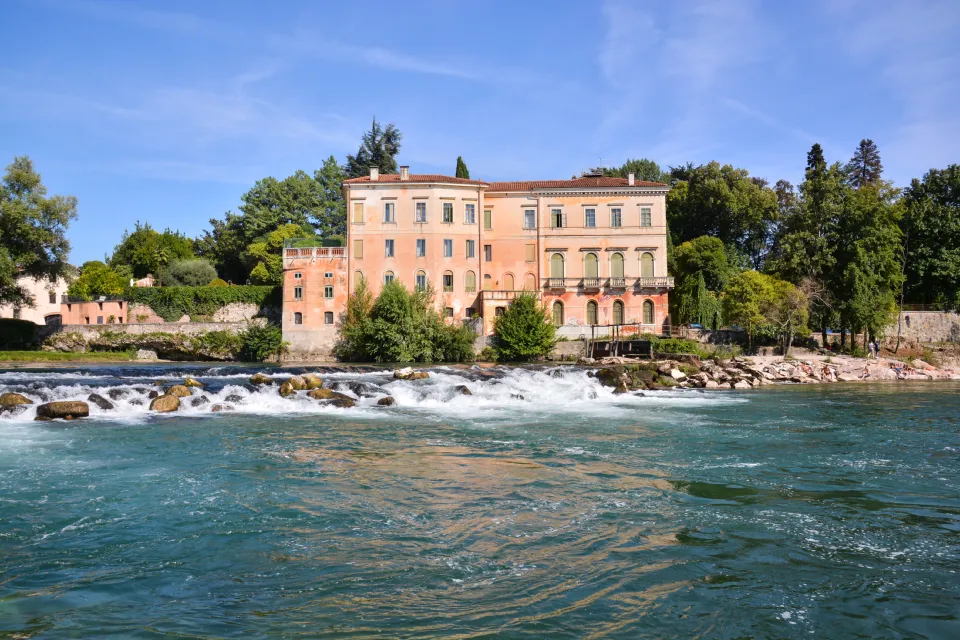 Brenta river rapids below a historic riverside palazzo in Bassano del Grappa