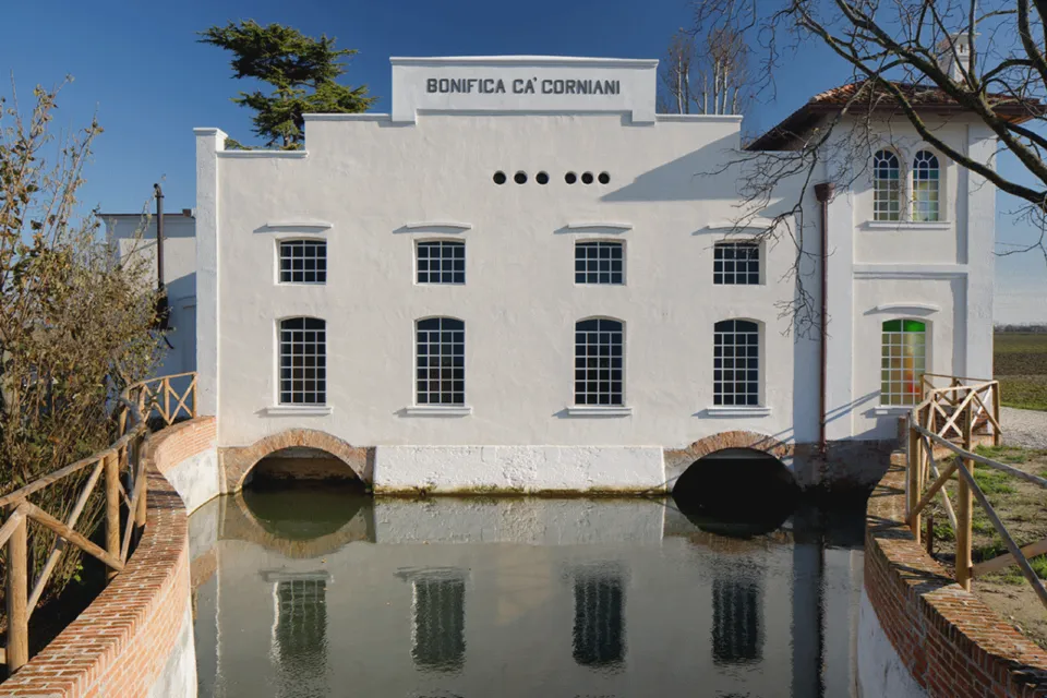 Historic Ca' Corniani pumping station reflected in its canal