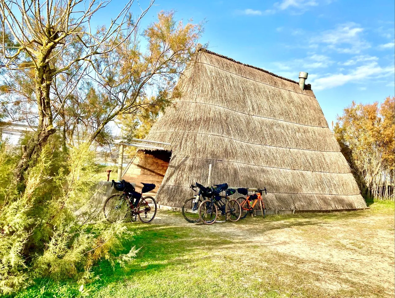 Traditional thatched fishermen's casone with bicycles parked in front, Caorle lagoon