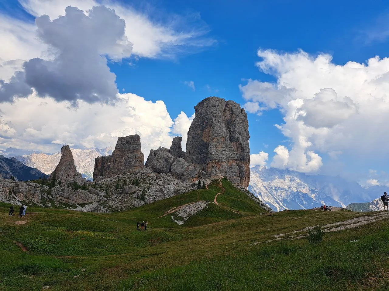The Cinque Torri rock towers above green meadows near Cortina d'Ampezzo