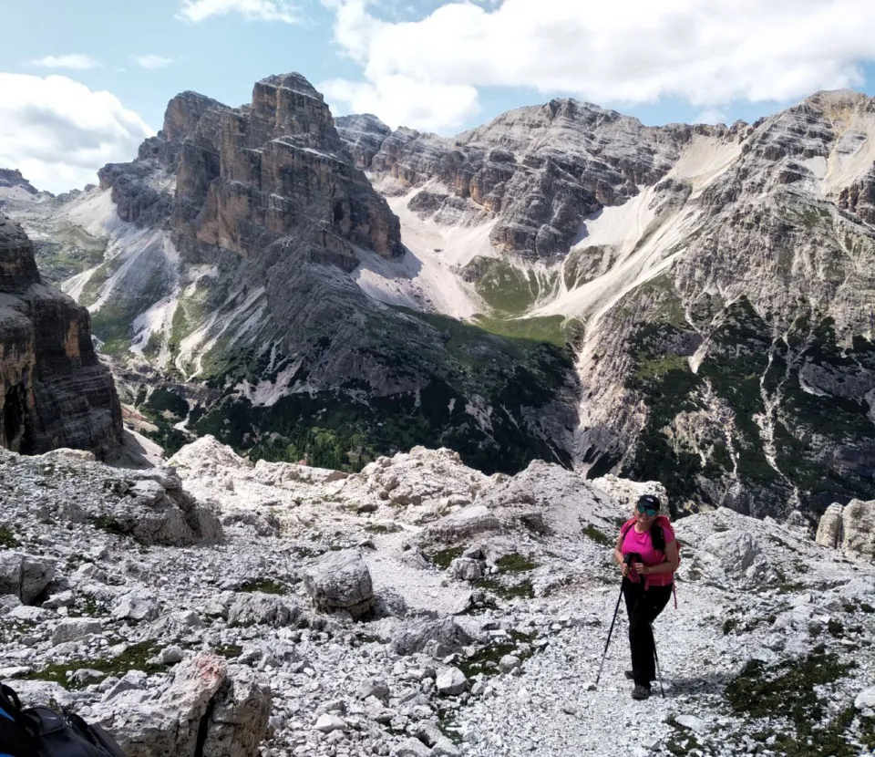 Hiker crossing a rocky basin surrounded by Dolomite peaks