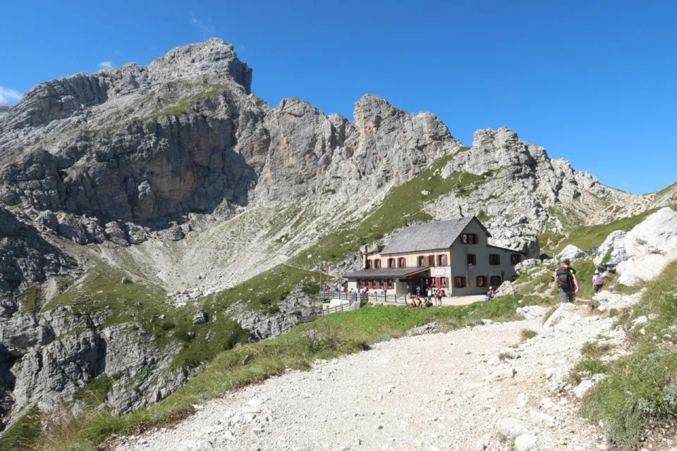 Mountain hut with a sunny terrace beneath limestone crags