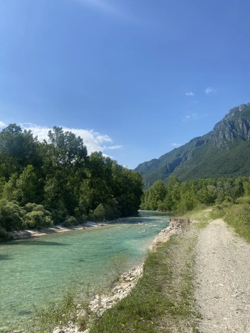 Turquoise river and gravel path at the foot of the mountains