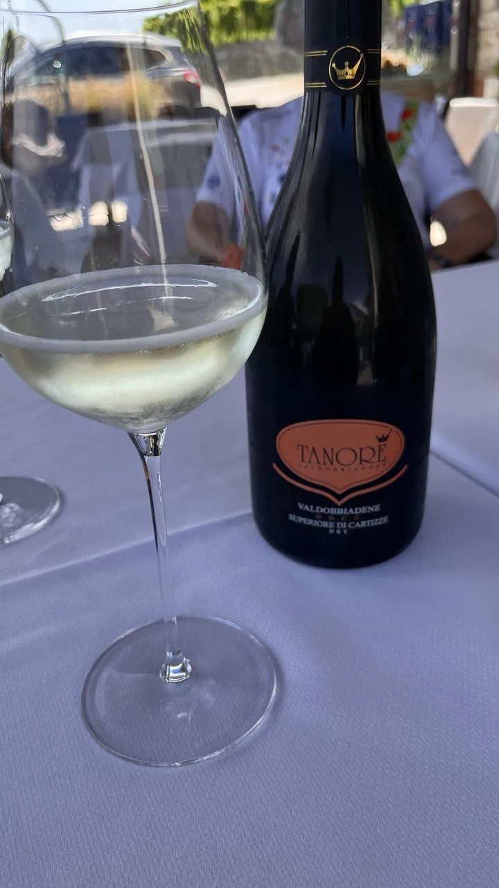 Glass of sparkling wine next to a bottle of Valdobbiadene Superiore di Cartizze